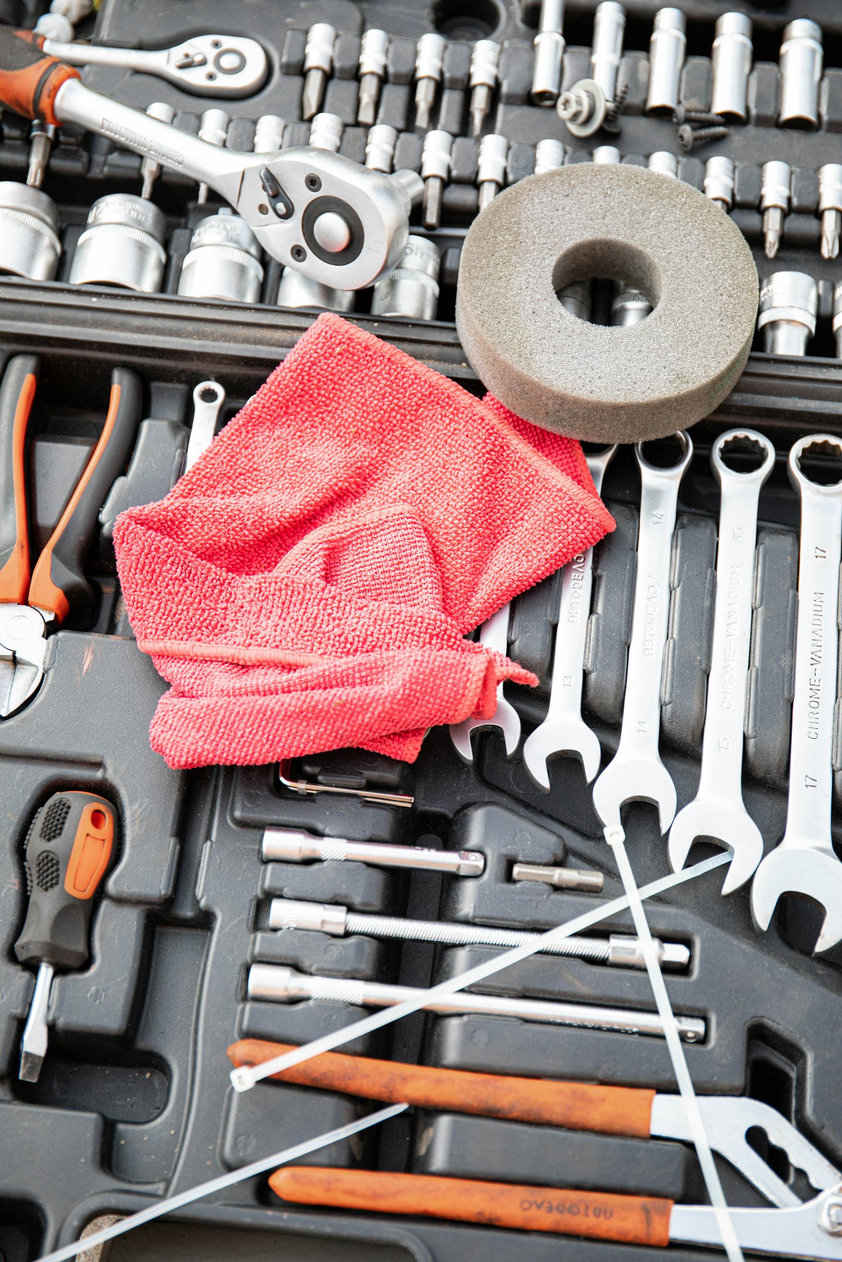 Close-up view of a versatile toolkit featuring wrenches, sockets, and a red cloth for maintenance needs.