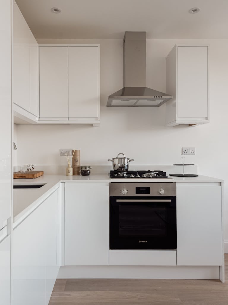 Minimalist white kitchen with sleek appliances in Warsaw